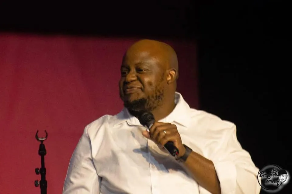 Oscar seated on stage in a white shirt