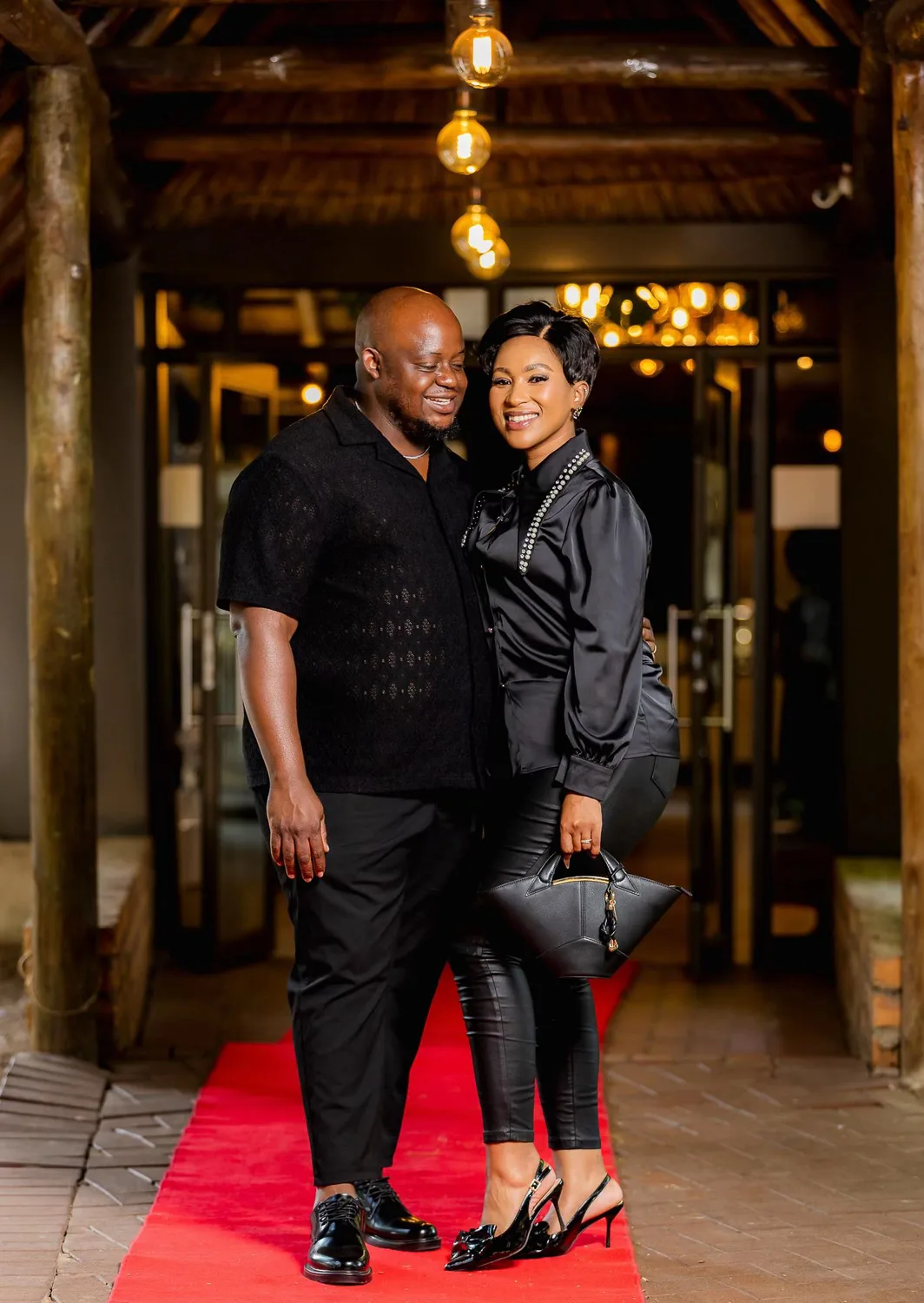 Oscar and Thandeka on a red carpet, both in black